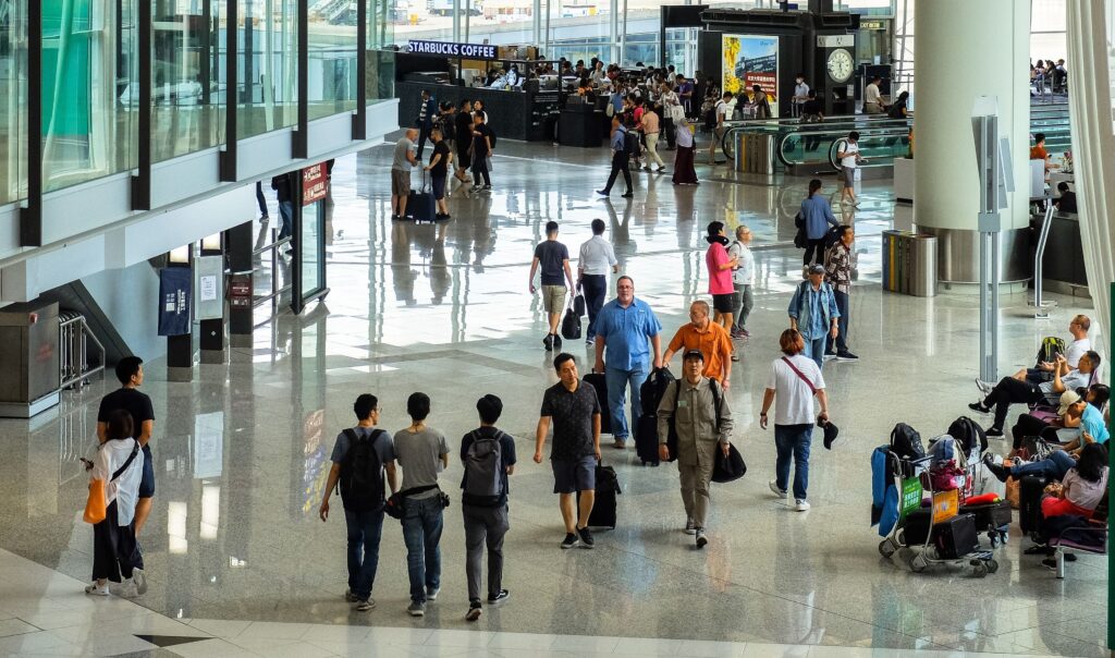 Travellers moving through an international airport terminal