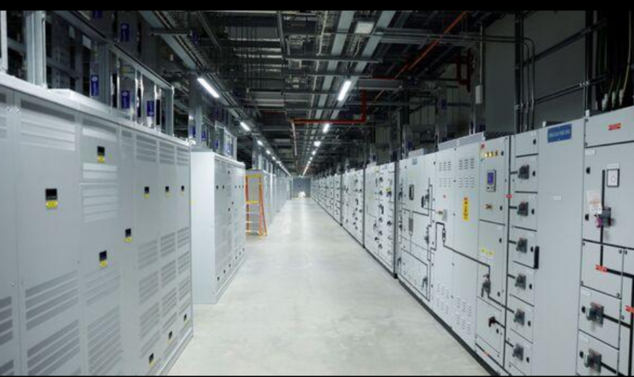 Rows of electrical switchgear and power distribution equipment inside a data centre.