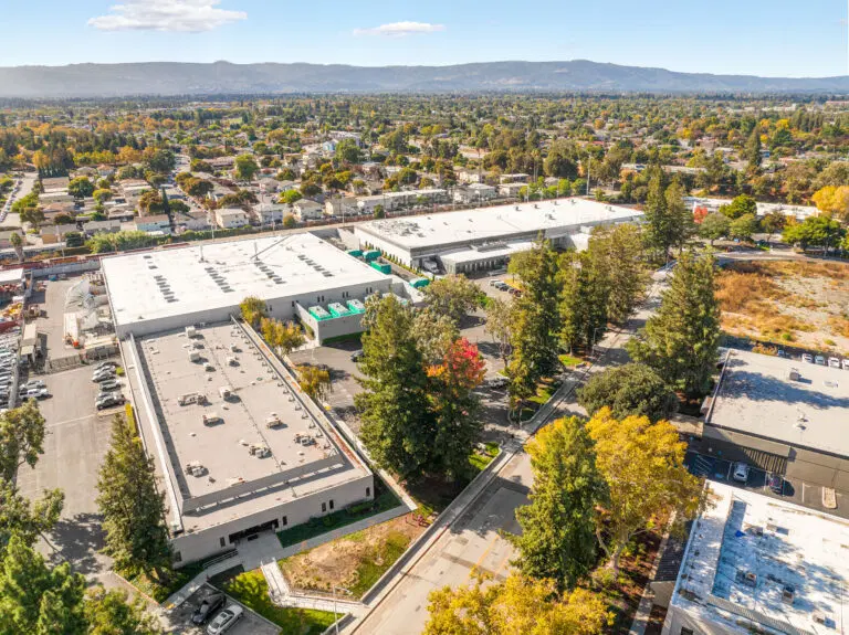 Aerial view of a low-rise AI infrastructure campus surrounded by trees, roads and other buildings in Silicon Valley